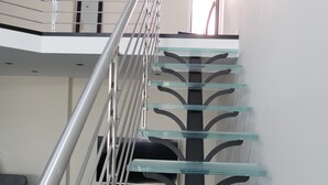 A modern staircase with glass railings and metal handrails. - Large chic and modern loft, industrial decor (Beausoleil)