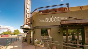 A pizzeria named 'BOCCE' with outdoor seating and a patio bar.