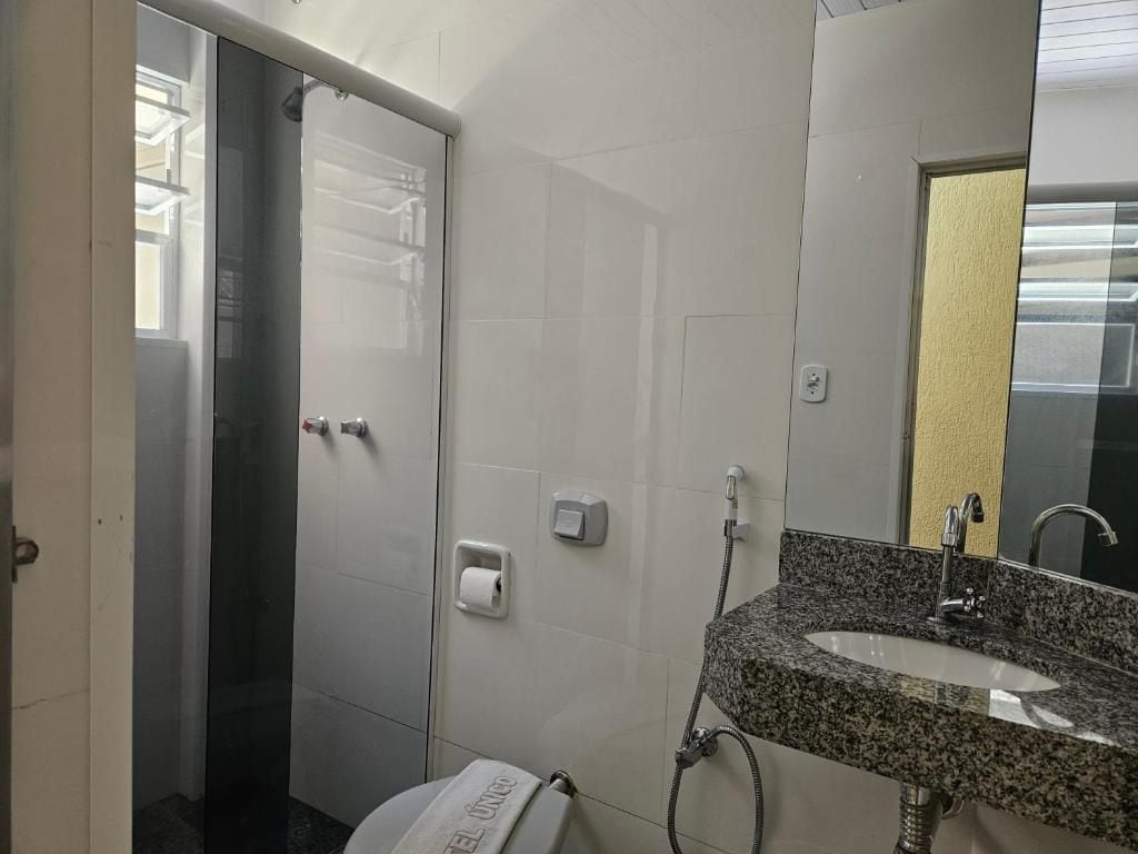 A bathroom with a toilet, sink, and shower.