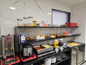 A buffet setup with various food items and condiments. - Hotel Único (Rio de Janeiro)
