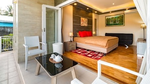 Un dormitorio moderno con cama, mesitas de noche, una pequeña mesa con tetera y una silla.