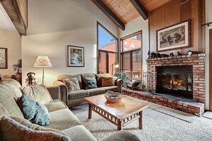 Una sala de estar acogedora con chimenea, ventanas amplias y asientos cómodos.