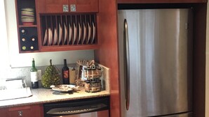 A kitchen with wooden cabinets, a stainless steel refrigerator, and a dishwasher. - Fishing, Golf & Beach Getaway! (Carrabelle)
