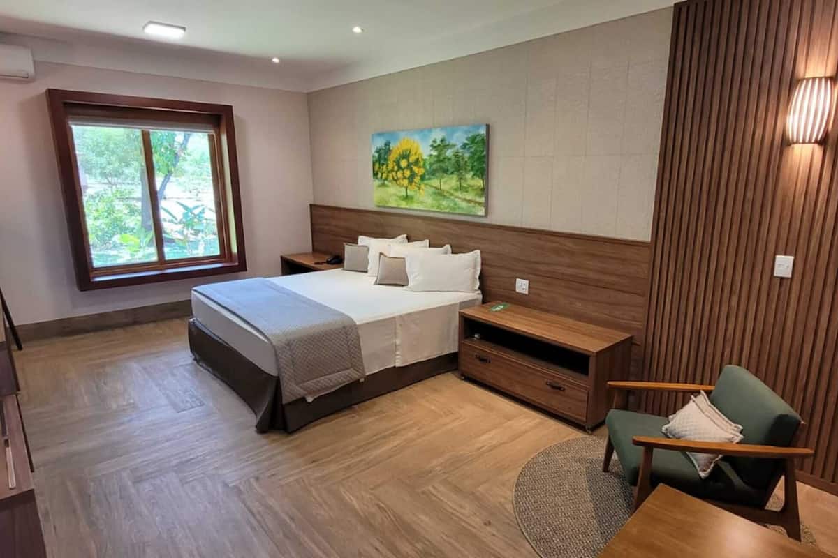 Habitación de hotel moderna con una cama grande, un escritorio, una silla y un cuadro en la pared.