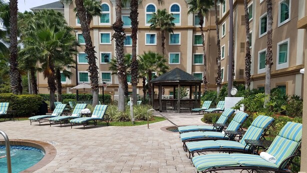 A poolside area with lounge chairs and a gazebo.