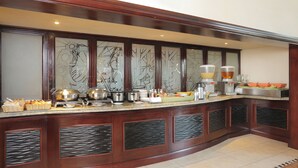 A buffet setup with various food items and kitchen appliances.