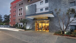 A hotel with a modern facade, large glass entrance, and a visible sign.