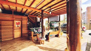 A wooden interior with a covered patio, wooden furniture, and a view of the street. - Pousada Beija Flor (Ubatuba)