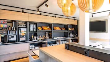 A modern kitchen with wooden cabinets, a coffee machine, and a large island with seating.