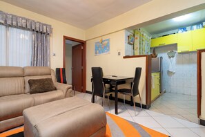 Apartamento família, 1 quarto | Área de estar | TV de tela plana