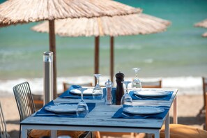 En la playa, sillas reclinables de playa, sombrillas, toallas de playa