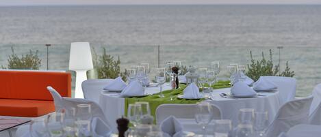 A table set for a meal with a view of the ocean.