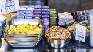 Un bufé de desayuno con diversas opciones de comida, incluyendo fruta, yogur y queso.