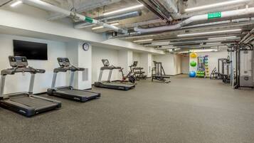 A gym with treadmills, stationary bikes, and various exercise equipment.