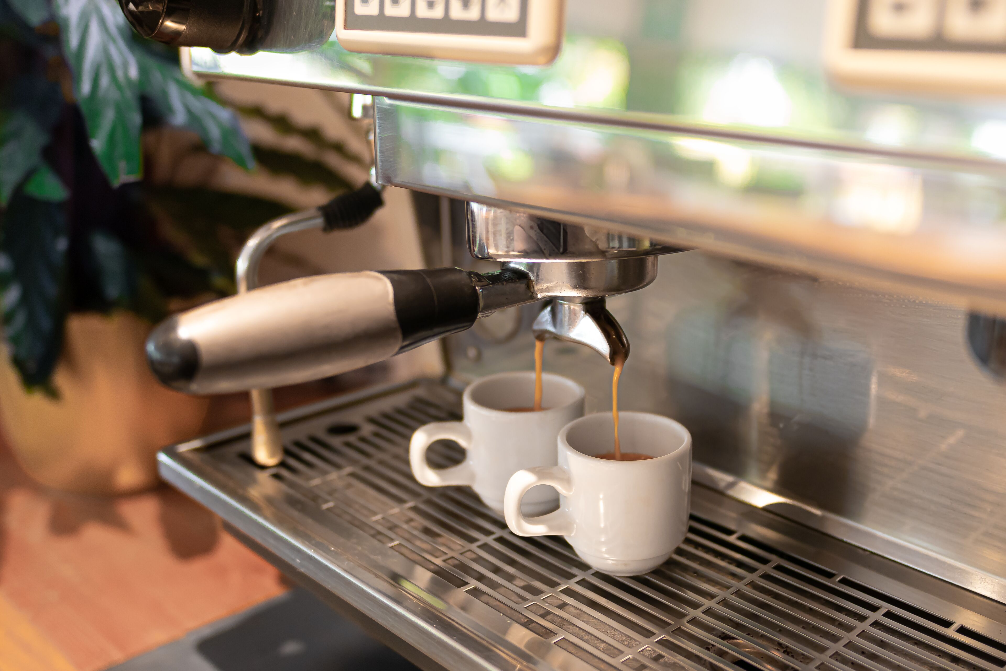 Eine Espressomaschine, die Kaffee in zwei weiße Tassen füllt.