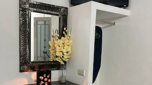A small workspace with a desk, chair, mirror, and TV. - Hostal Casa Blanca (Comala)