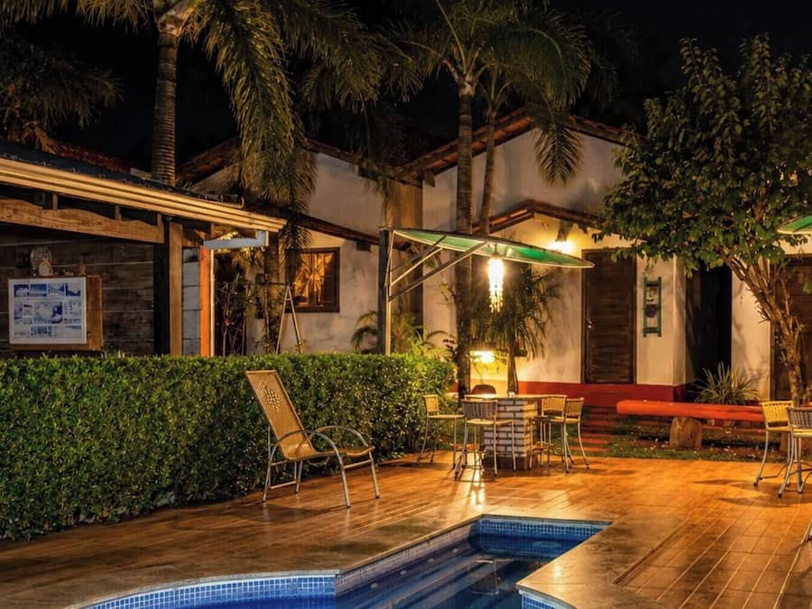 An outdoor swimming pool area with lounge chairs and a covered seating area.