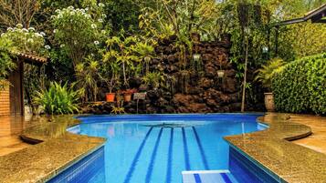 Una piscina al aire libre, sombrillas