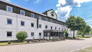 Un hôtel-restaurant de type « bed and breakfast » au design moderne, doté de nombreuses fenêtres et d’un jardin bien entretenu.