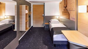 Une chambre d’hôtel moderne équipée d’un lit, de tables de chevet, d’une armoire et d’une carte accrochée au mur.