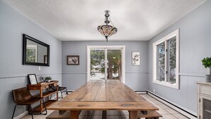 Comedor con mesa de madera, sillas y candelabro.