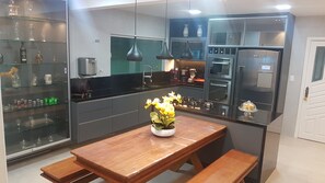 Enjoy cooking in this well-equipped kitchen with a central island, glass display case, and stainless steel appliances.