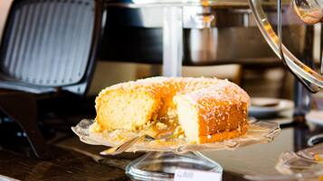 A cake on a glass stand with a price tag.