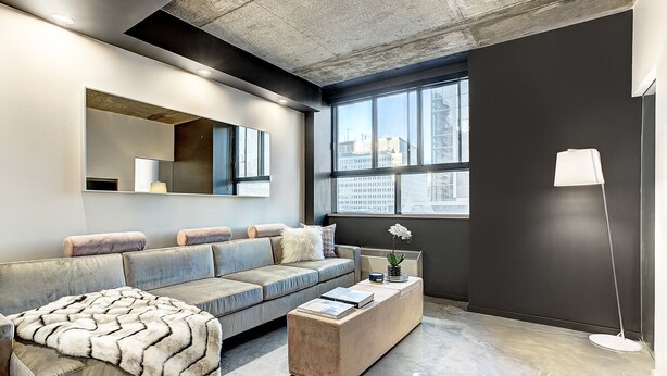 Un salon moderne avec un canapé, une table basse et un lampadaire.