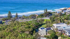 A coastal residential area with houses, a road, and a beach. - Surfside - Shelly Beach Holiday Home (East Ballina)