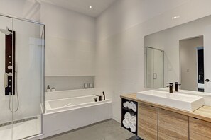 A modern bathroom with a glass-enclosed shower, a freestanding bathtub, and a vanity with a large mirror. - THE YIN | One-Bedroom Loft w. Terrace (Montréal)