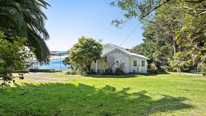 Une maison de plain-pied avec un jardin devant, une petite piscine et une vue dégagée sur l’océan.