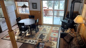 Un interior acogedor con una mesa de comedor, sillas, un sofá, chimenea y una zona de cocina.