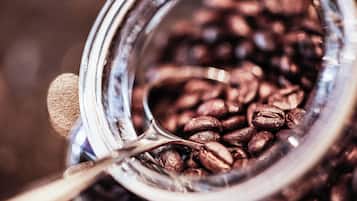 Ein Nahaufnahme eines Glases, gefüllt mit Kaffeebohnen und einem Löffel.
