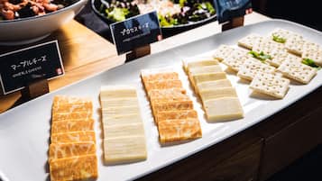 A variety of cheeses and crackers on a white plate, with labels indicating different types.