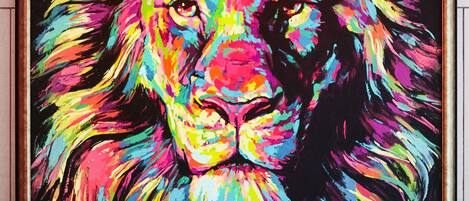 Un cuadro enmarcadosel rostro de un león con un fondo abstracto y colorido.
