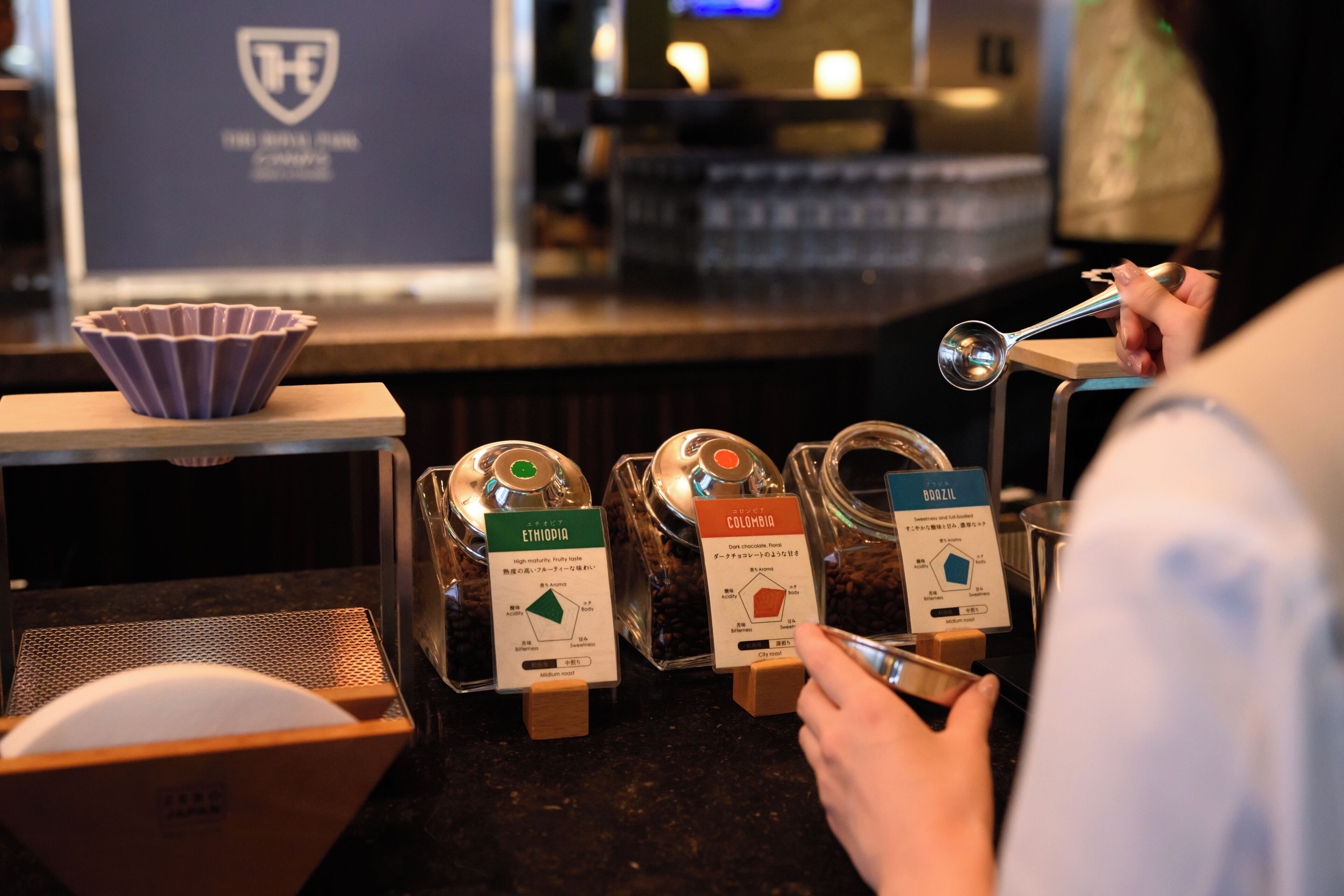 A coffee shop counter with labeled coffee beans from Ethiopia and Colombia.