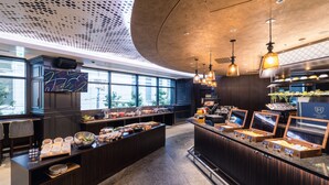 Un espace cuisine moderne avec un buffet proposant une variété de plats et un écran numérique.