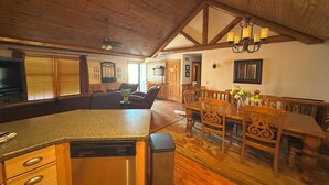 A spacious kitchen with a dishwasher, wooden cabinets, and a dining area with a table and chairs. - Apple Canyon Lake, Game Room, Hot Tub (Apple River)