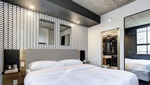 A modern bedroom with a large bed, a wardrobe, and a mirror. - Roomy Loft near Guy-Concordia Metro (Montreal)