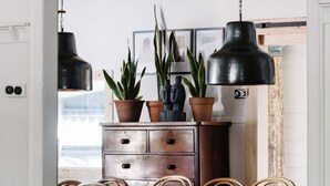 A room with a wooden dresser, two potted plants, a black pendant light, and a framed picture on the wall. - The Oxford ~ Hepburn Springs/Daylesford ~ Sleeps 24 (Hepburn Springs)