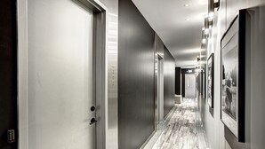A hallway with doors, a carpeted floor, and framed pictures on the walls. - THE BOHO CHIC | Two-Bedroom Loft w. Terrace (Montréal)