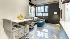 A modern living room with a dining area, a sofa, and a coffee table. - Modern Apartment with All Amenities (Montreal)