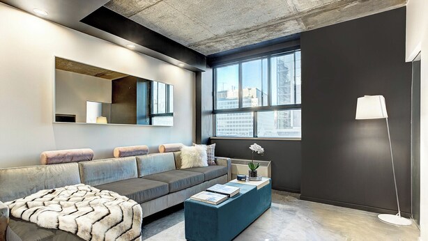 A modern living room with a sofa, a coffee table, a large mirror, and a floor lamp. - Modern Apartment with All Amenities (Montreal)