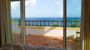 Ein Zimmer mit großem Fenster und Balkon mit Meerblick.