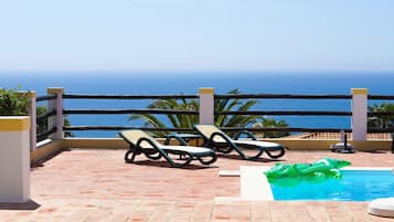 Een buitenzwembad, een verwarmd zwembad en ligstoelen