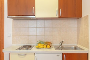 A kitchen with wooden cabinets, a white countertop, a sink, and a dishwasher. - Apartment Mondo A2 - One Bedroom Apartment, Sleeps 2 (Mokosica)