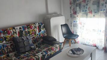 Un salon comprenant un canapé, un fauteuil, une table basse et un appareil de climatisation.