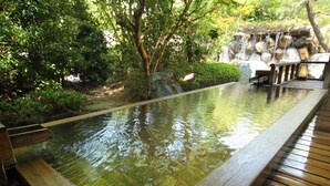 A wooden deck surrounding a rectangular pool with a waterfall feature. - Misasa Onsen MISASAKAN (Misasa)
