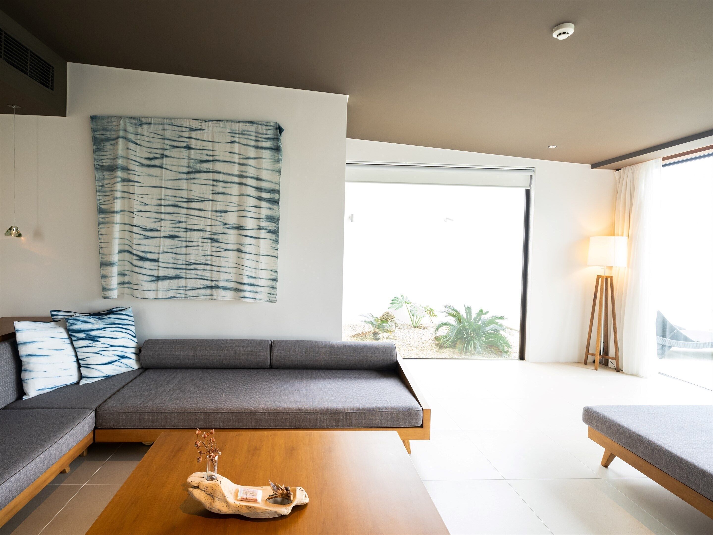 Un soggiorno moderno con un divano ad angolo grigio, un tavolino in legno e un grande quadro astratto appeso alla parete.
