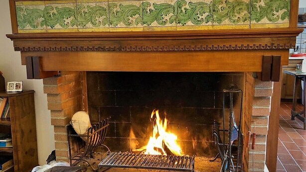 A fireplace with a tiled mantel and a metal grate. - Large apartment big lounge fireplace two terraces (Venezia)